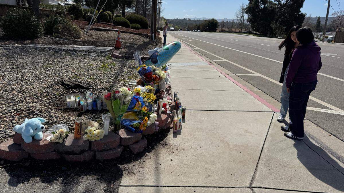 Mourners visit a makeshift memorial on Saturday, March 15, 2025, for an 11-year-old Atascadero boy who was killed the day before in a hit-and-run near the Danish Care Center on El Camino Real. A gray pickup truck hit the boy on the sidewalk and then drove off.