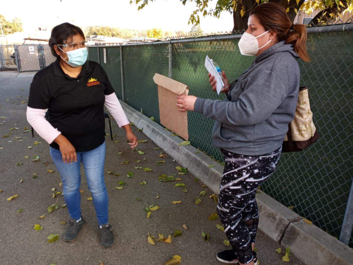 Promotora Eustolia Garcia hands out materials about COVID-19 to a SLO County resident. The Promotores Collaborative of San Luis Obispo County has been supporting Spanish-speaking families and working with the county Public Health Department to distribute information about the coronavirus.