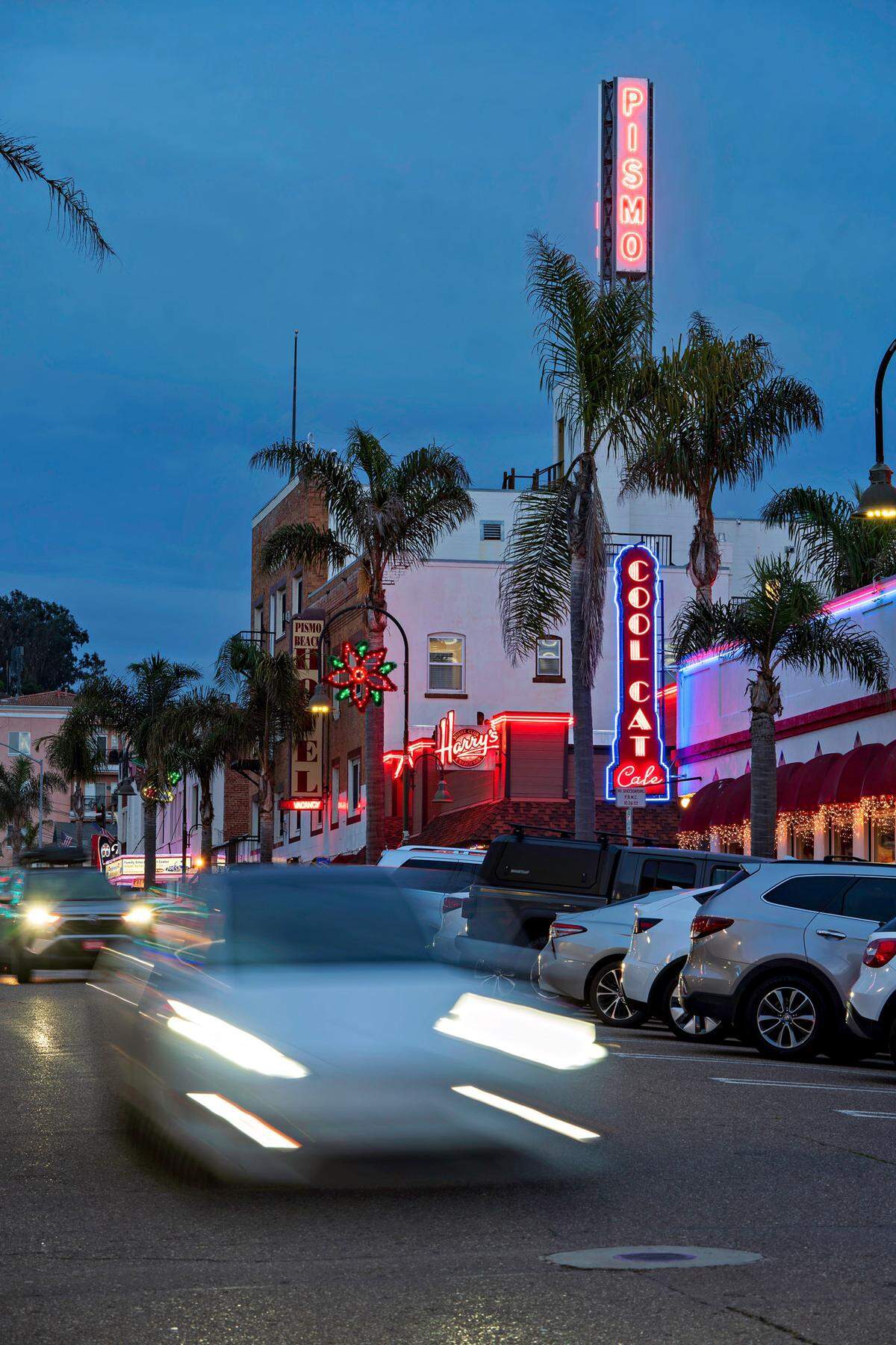 Cars drive through downtown Pismo Beach.