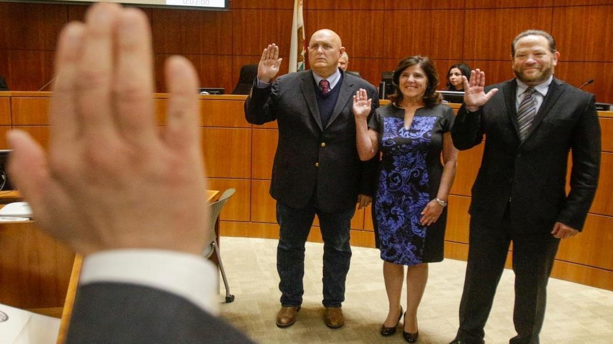 San Luis Obispo County Clerk-Recorder Tommy Gong administers the oath of office to San Luis Obispo County Supervisors, from left, John Peschong, Debbie Arnold and Adam Hill.