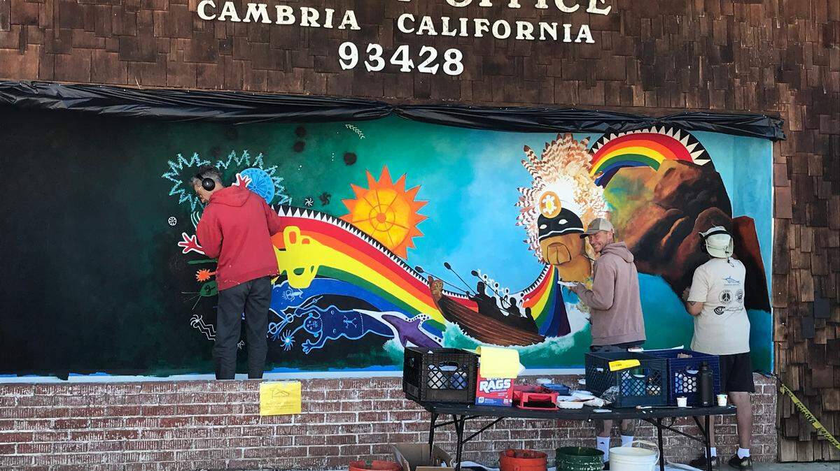 Artist John Khus, right, and his assistants finish a mural on the heritage of the Chumash tribe on Sunday, Aug. 13, 2023, at the Post Office on Bridge Street in Cambria.