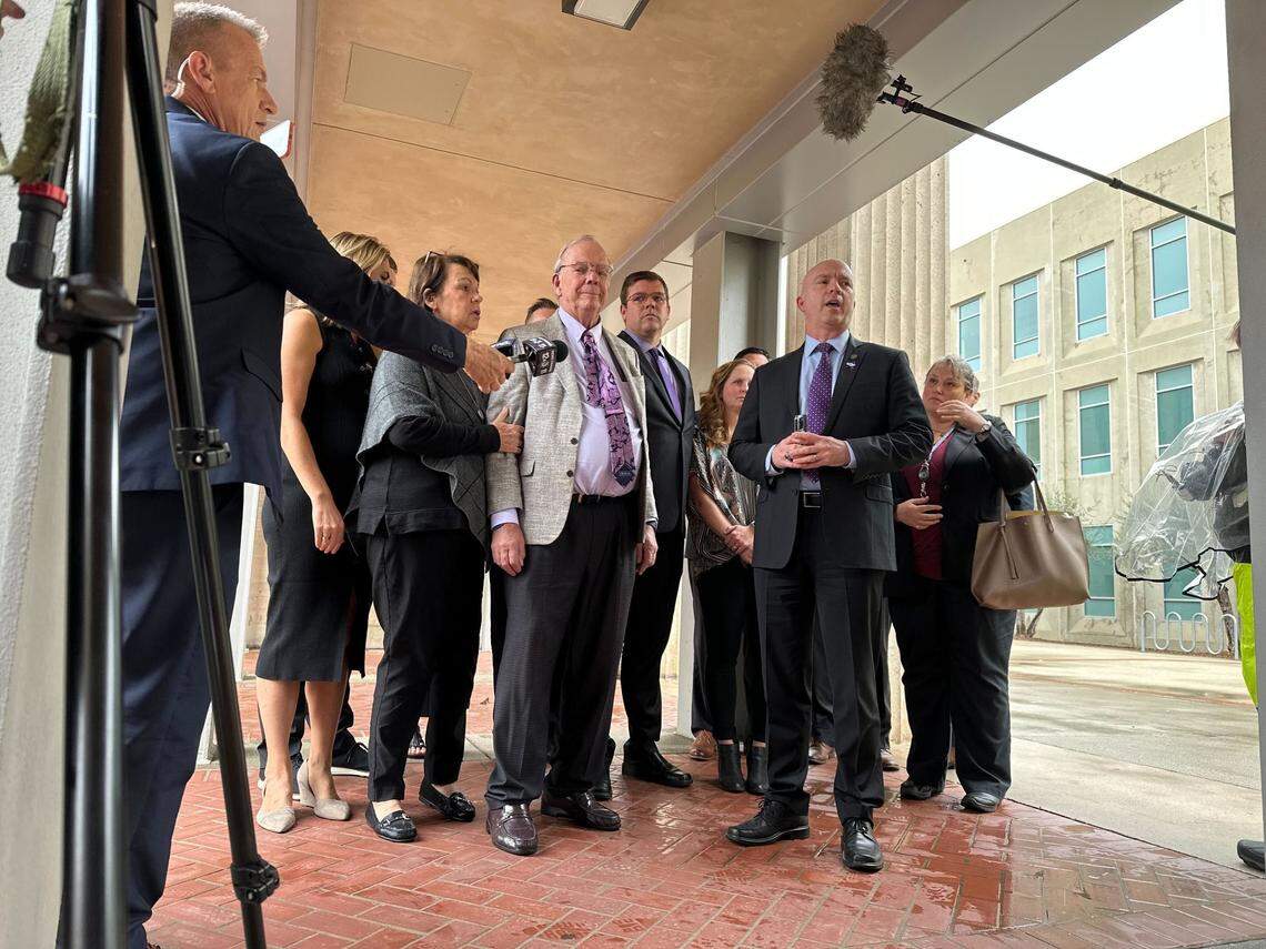 District Attorney Dan Dow speaks to the media surrounded by Kristin Smart’s family outside the Monterey County Courthouse on March 10, 2023, after Paul Flores was sentenced to 25 years to life in prison.