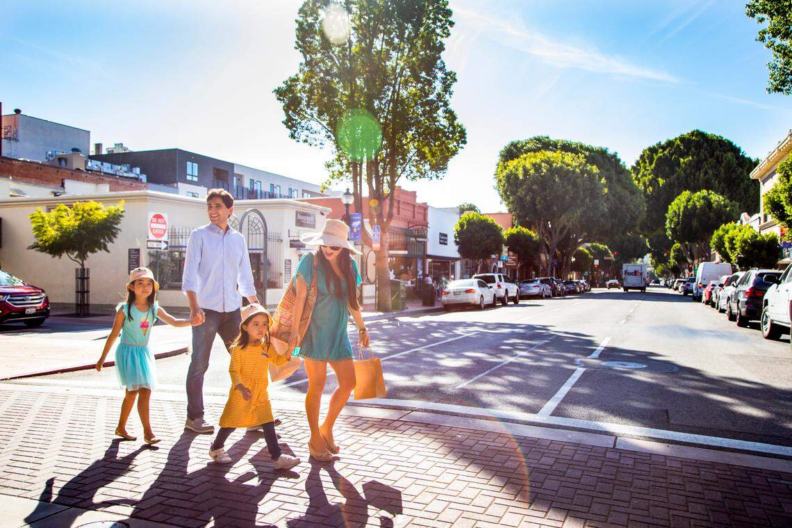 Visitors of SLO’s downtown with trees in the background.