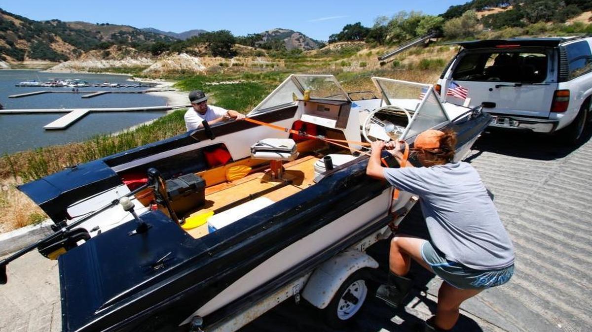 John and Ashlyn Hoop secure their boat to a trailer after removing it from July 2016.