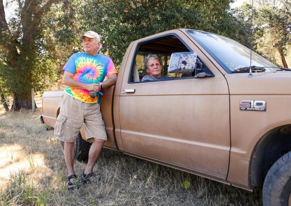 Richard Lang and his wife Judy Baker watch the road closure at Highway 58 and Huer Huero Road on Tuesday as firefighters gained groud on the Hill Fire in Santa Margarita.