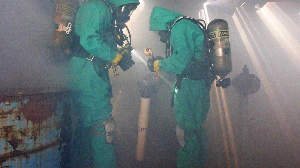 Members of the San Luis Obispo Regional Hazardous Materials Response Team work to repair broken pipes and contain industrial chemicals in a training building Wednesday as part of a hazardous waste and oil train derailment training exercise at Camp San Luis Obispo and the California Men’s Colony.