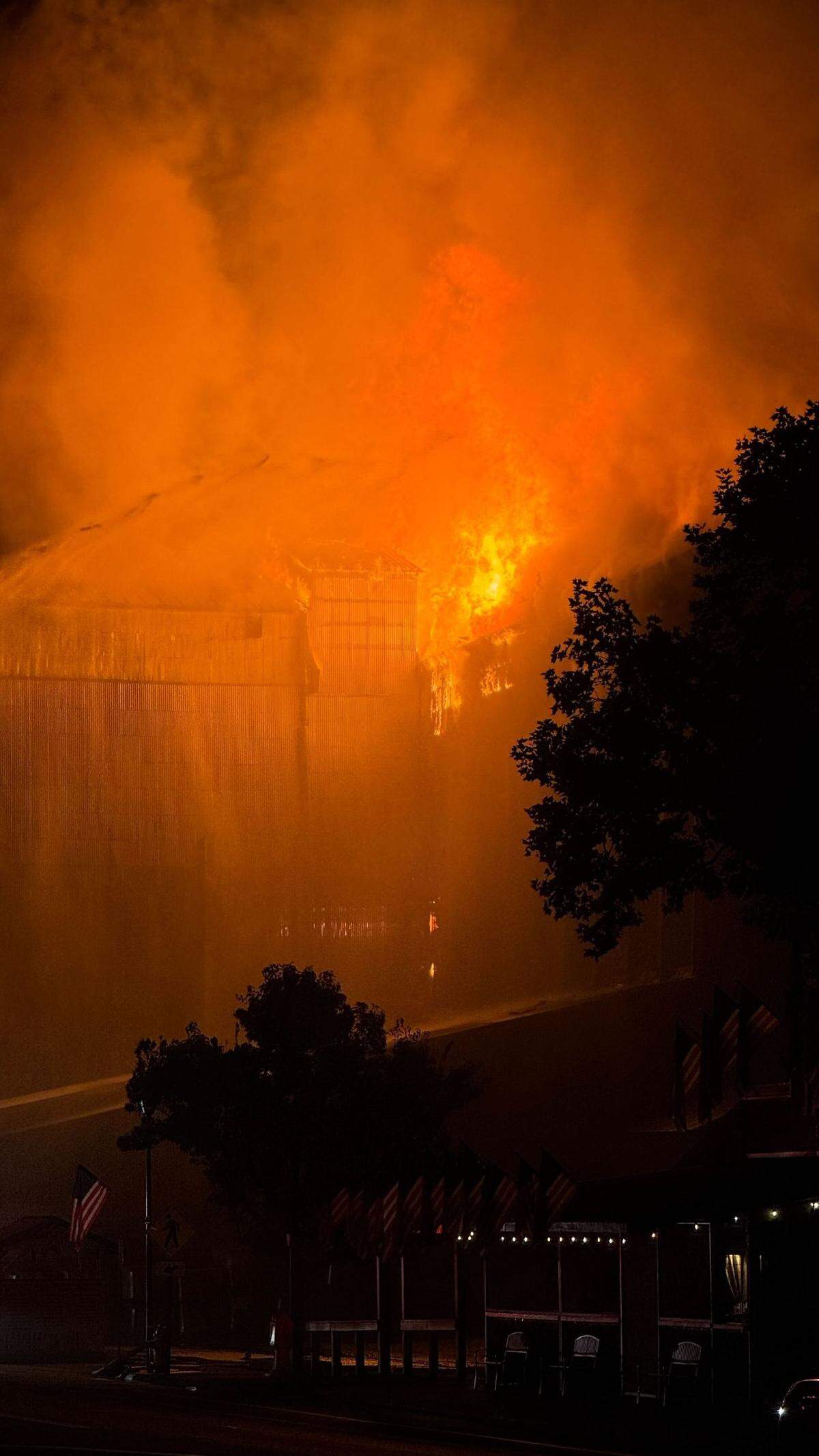 Flames could be seen erupting from the upper floor and roof area of Templeton Feed & Grain early July 5, 2025, as firefighters attempted to save the building.&nbsp;