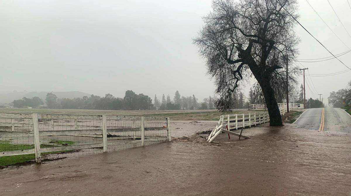 Floodwaters knocked down a fence and inundated Templeton Road east of Atascadero on Monday, Jan. 9, 2023.