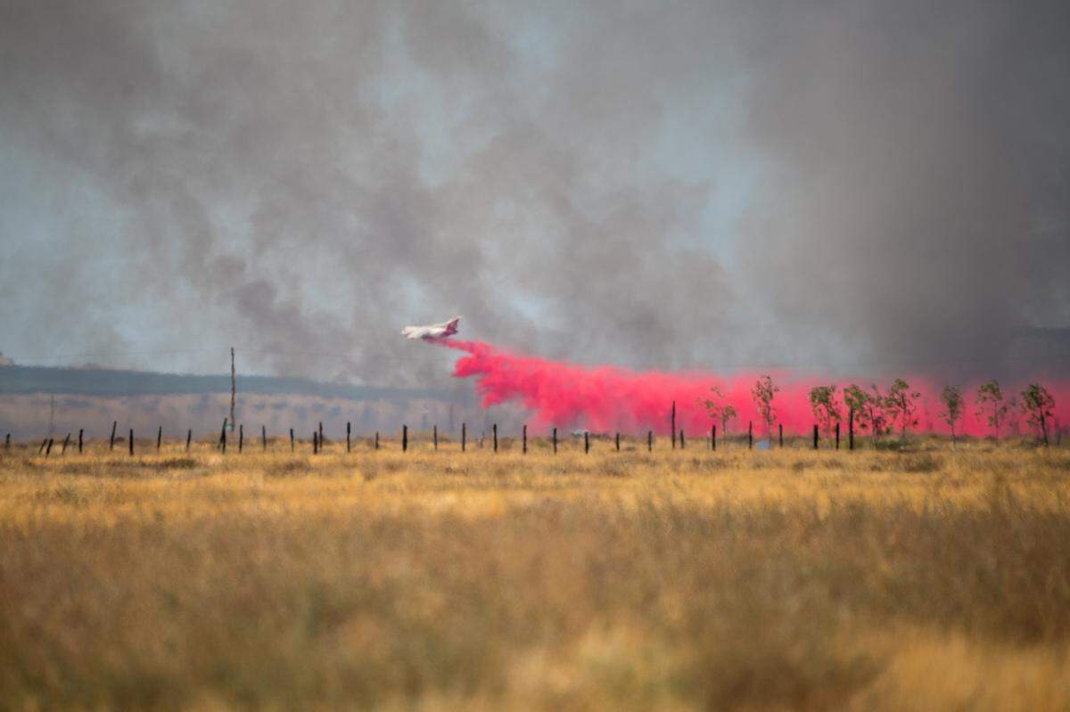 A Cal Fire plane drops retardant on a fire that burned 500 acres in California Valley on Monday, Sept. 30, 2024.