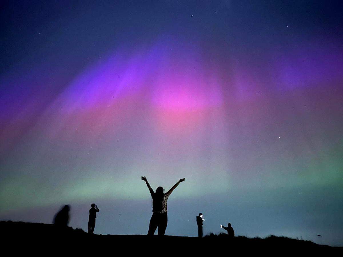The northern lights illuminate the skies over Edinburgh, Scotland, in pinks and greens on Friday night, May 10, 2024.