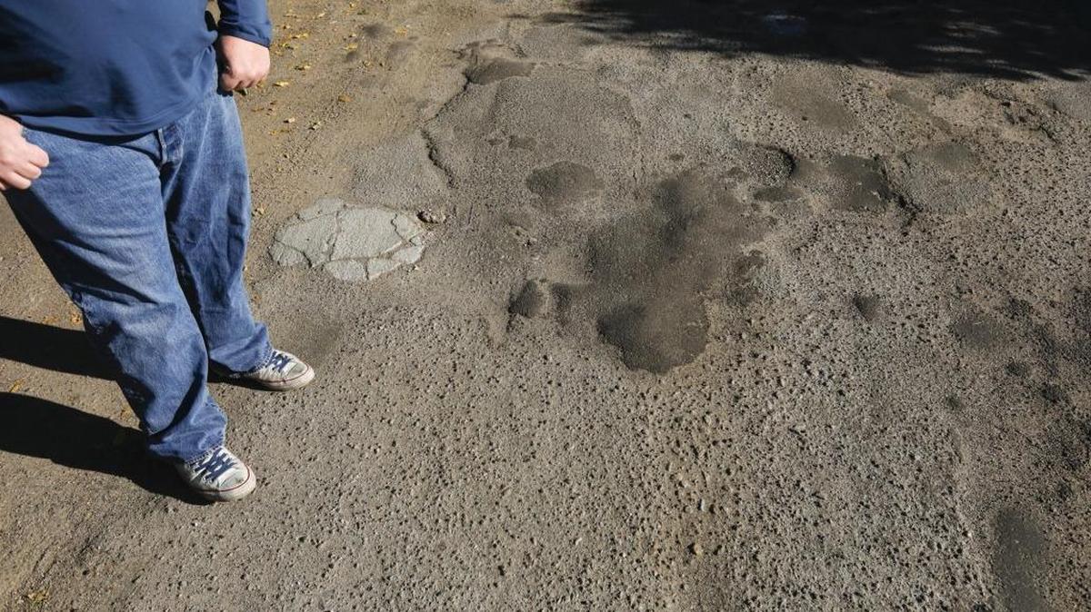 Bill Mavety stands on a patchy piece of Amapoa Avenue in Atascadero — a road that was never accepted into the city’s system.