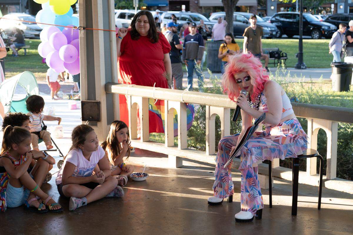 Foxy Moron, a drag queen, reads kids a book during Paso Pride in downtown Paso Robles on June 24, 2022.