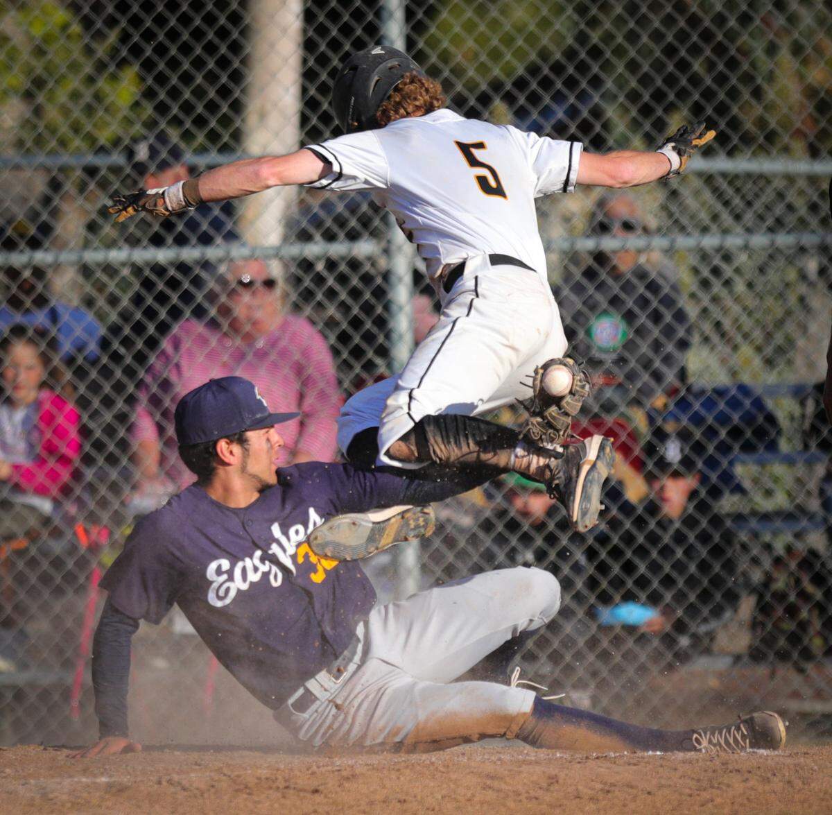 Bo Victor gets tangled with pitcher Kaden Tynes at home, Victor scored on the wild pitch after the ball fell out of Victor’s mitt. San Luis Obispo won 3-1 over Arroyo Grande in a baseball game in SLO on May 12, 2022.