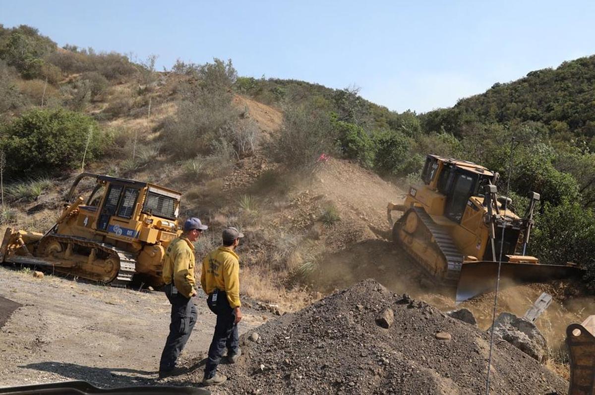Bulldozers finished carving a containment line Wednesday from the ridge of the Santa Ynez Mountains down to Highway 154 on the east side of the Whittier Fire.