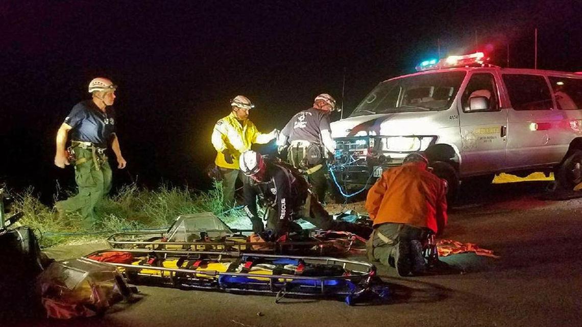 Emergency personnel prepare to rescue people from a vehicle that plunged off Gibraltar Road on Monday, June 26, 2017.