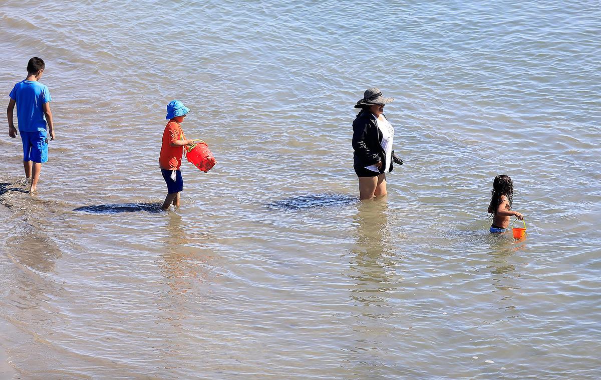 Beachgoers wade in the water at Avila Beach on Saturday, July 13, 2019. The beach has been closed because of a sewage spill that entered San Luis Obispo Creek, which flows into the ocean.