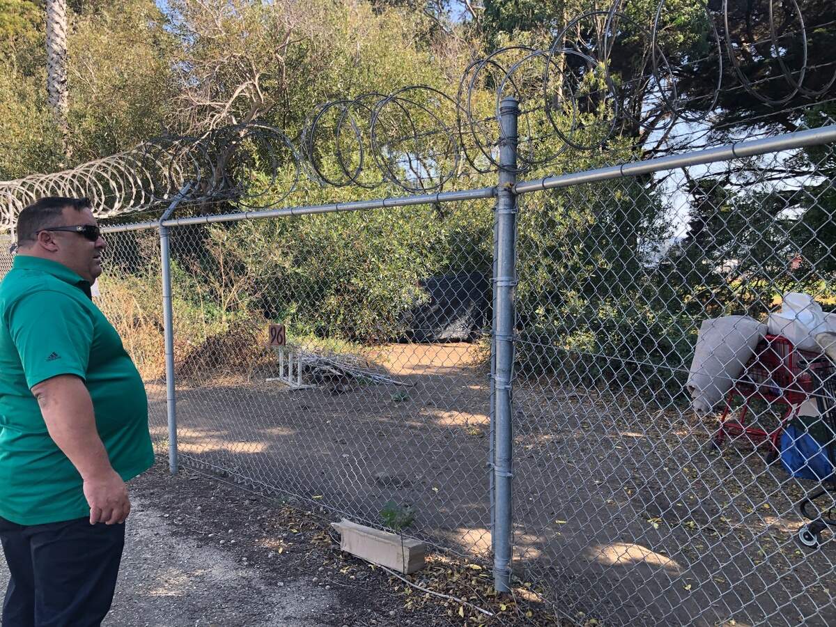 Reggie Greenwood, manager of SLO’s Elks Lodge, looks beyond the fence of the property’s RV storage area. Greenwood said anywhere from 200 to 250 campers have been staying in the San Luis Obispo Creek area and often trespassing on the lodge grounds.