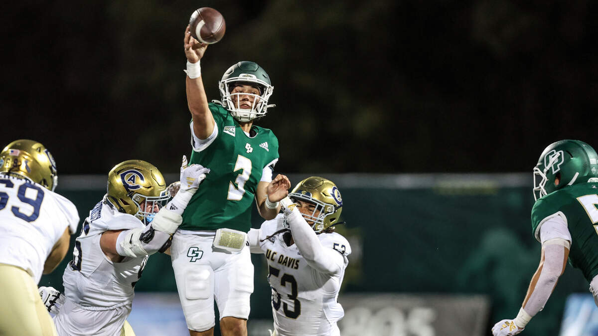 Cal Poly quarterback Bo Kelly throws a pass under pressure by UC Davis linebacker Nick Eaton (53) and others during the Mustangs’ 31-13 loss to the Aggies on Saturday.