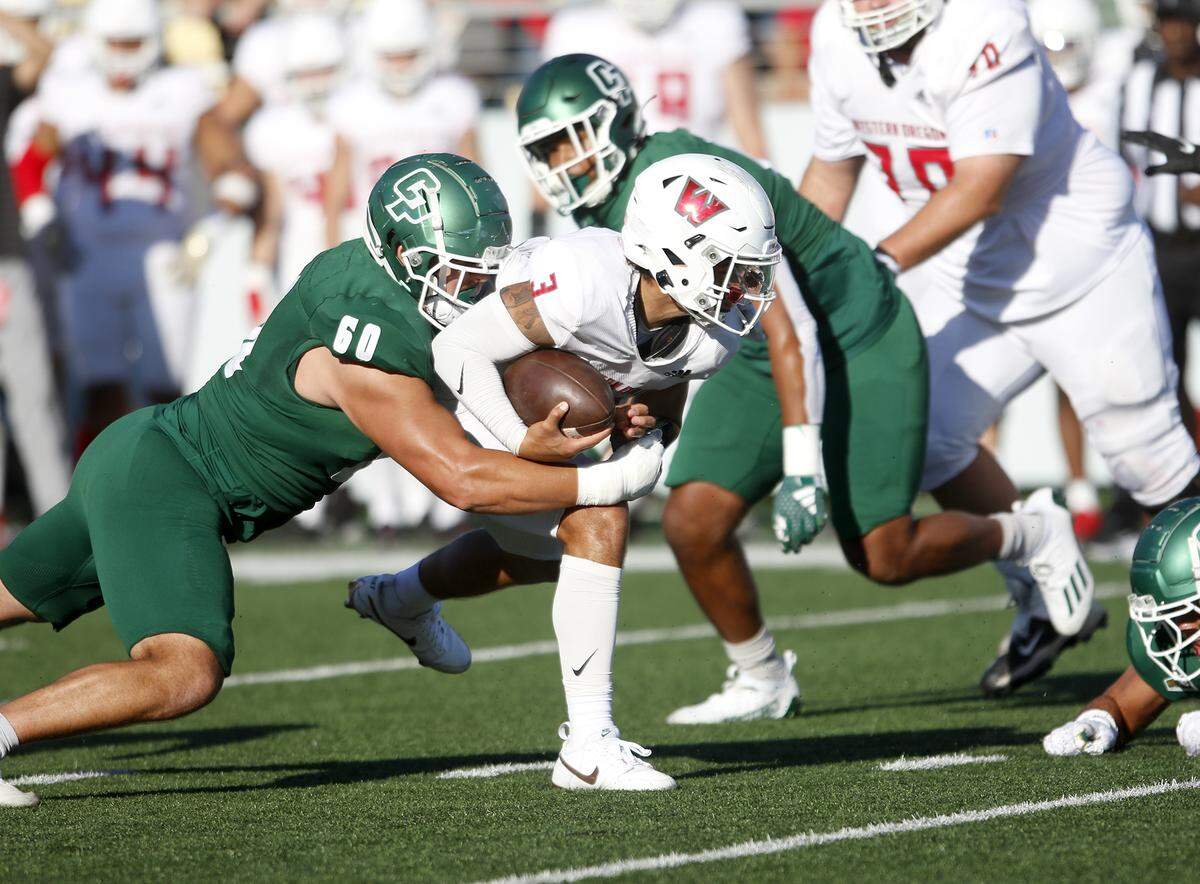 Western Oregon ball carrier Malcom Liufau is tackled by Ethan Rodriguez as Cal Poly SLO football beat Western Oregon 31-14 at Mustang Memorial Field on Sept. 14, 2024.