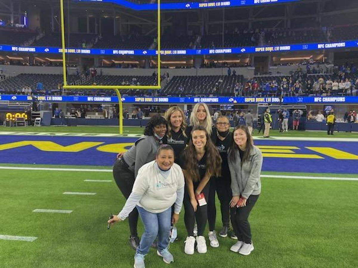 Staff members of VIP Nannies celebrate at SoFi Stadium after a recent playoff game. Rebecca Stewart, a 1999 San Luis Obispo High School grad, owns the business, which cares for children of Los Angeles Rams players and will be working during the Super Bowl. 