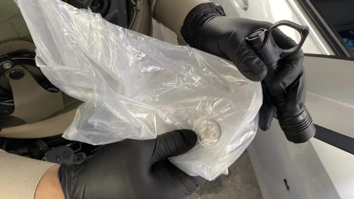 A Santa Barbara County sheriff’s deputy holds a bag containing a stolen package with AirTag on it. A woman mailed the package to herself with the AirTag inside after her mail had been stolen repeatedly. The package was then stolen from the Los Alamos Post Office, and deputies were able to track the suspects to Santa Maria.