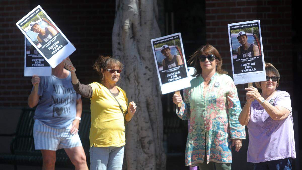 Mary Jane Jodry in green and husband Bill (outside frame) lead a vigil for their son Thomas who died three years ago in a fall from the Marsh Street parking garage in San Luis Obispo. They are still looking for witnesses who might have answers to the events of Sept. 14, 2019.