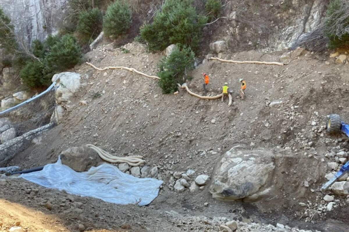 Workers repair the sides of the stream in San Ysidro Creek after cleaning out the nearby debris net.