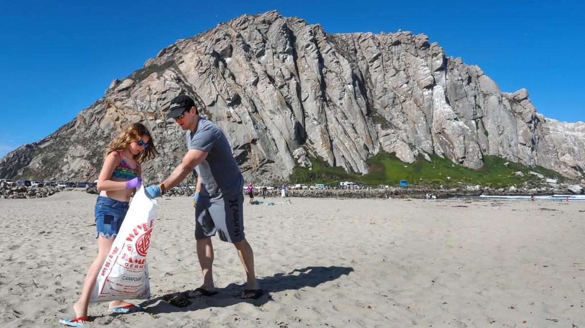 Cate Markowitz, 9, and father Wayne gather trash north of Morro Rock on Sunday morning.