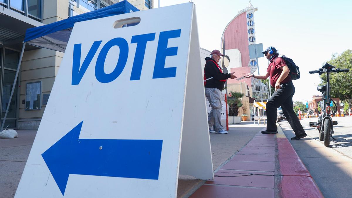 Robert Broughton rode a scooter to the San Luis Obispo County Government Center and gave his ballot to elections volunteer Larry Merkle, left, who dropped it in the curbside ballot box. Sept. 14, 2021, was Election Day in the recall race that will decide whether Gov. Gavin Newsom will remain in office or be replaced by another candidate.