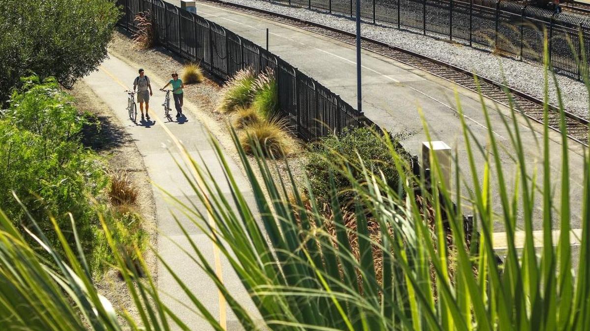 A pair of cyclists walk along the the Railroad Safety Trail near the train station in San Luis Obispo. The city of San Luis Obispo has received a $3.2 million grant to complete a section of trail from Taft to Pepper streets.