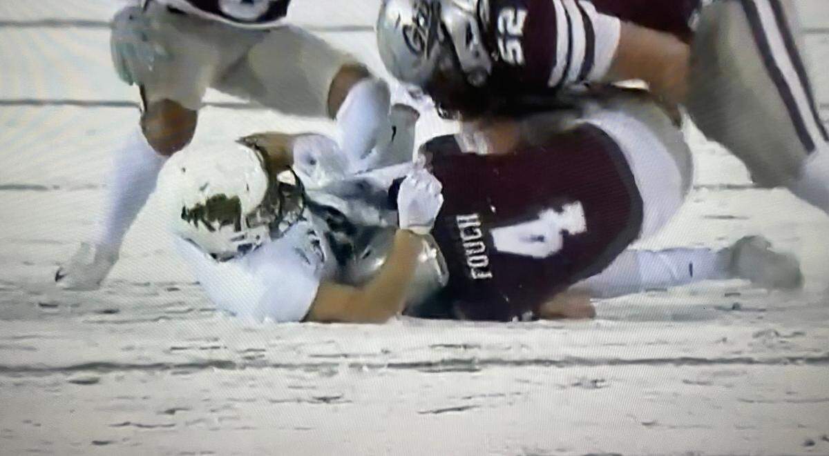 A Cal Poly ball carrier is tackled during the Mustangs’ 57-0 loss to Montana in a snowy game on Nov. 5, 2022.