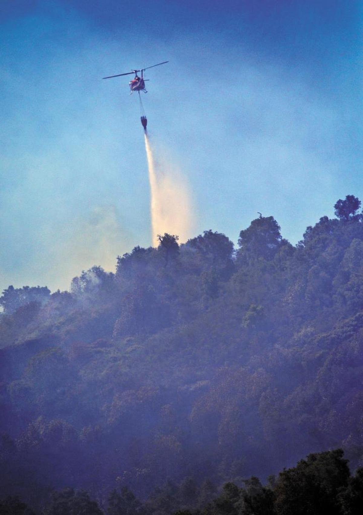 A helicopter drops water on the Cuesta Fire on Aug. 19, 2015. The fire, allegedly sparked by a tow chain, burned 2,500 acres.