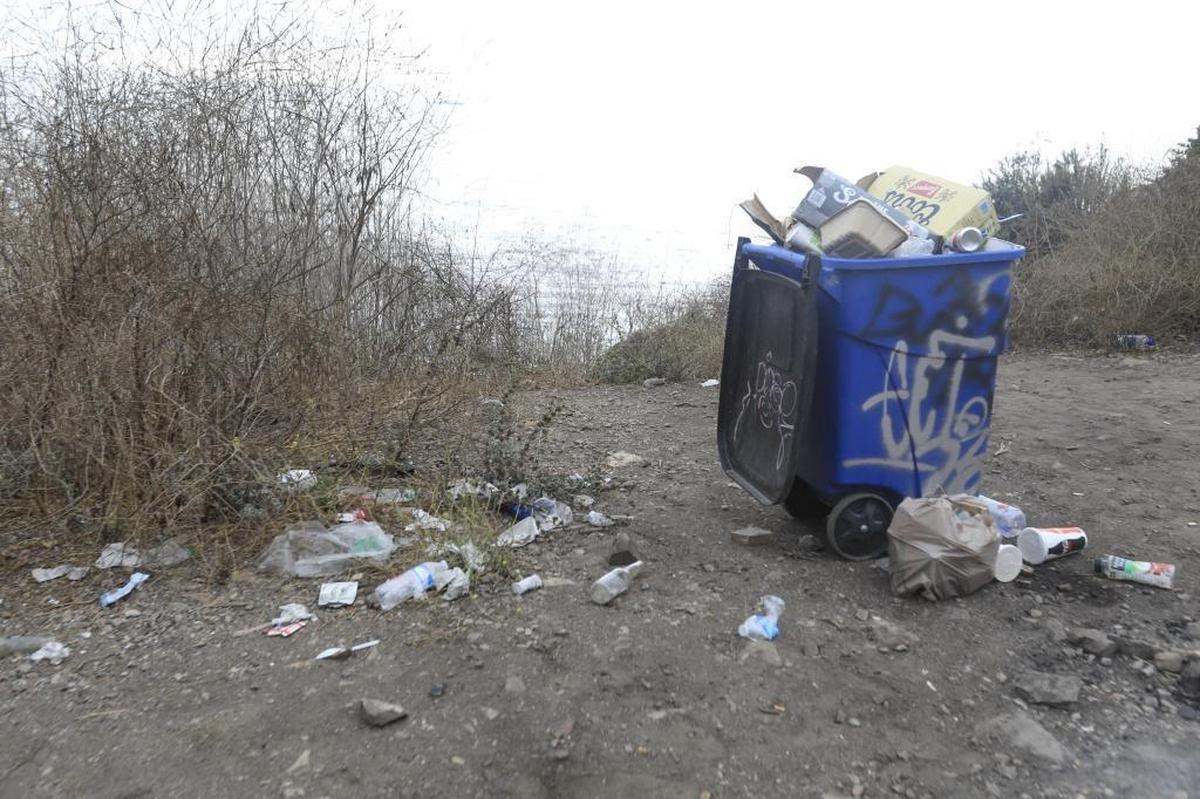 At Pirate’s Cove, a lone trash can that was brought in by volunteers is defaced with graffiti and overflowing with garbage.