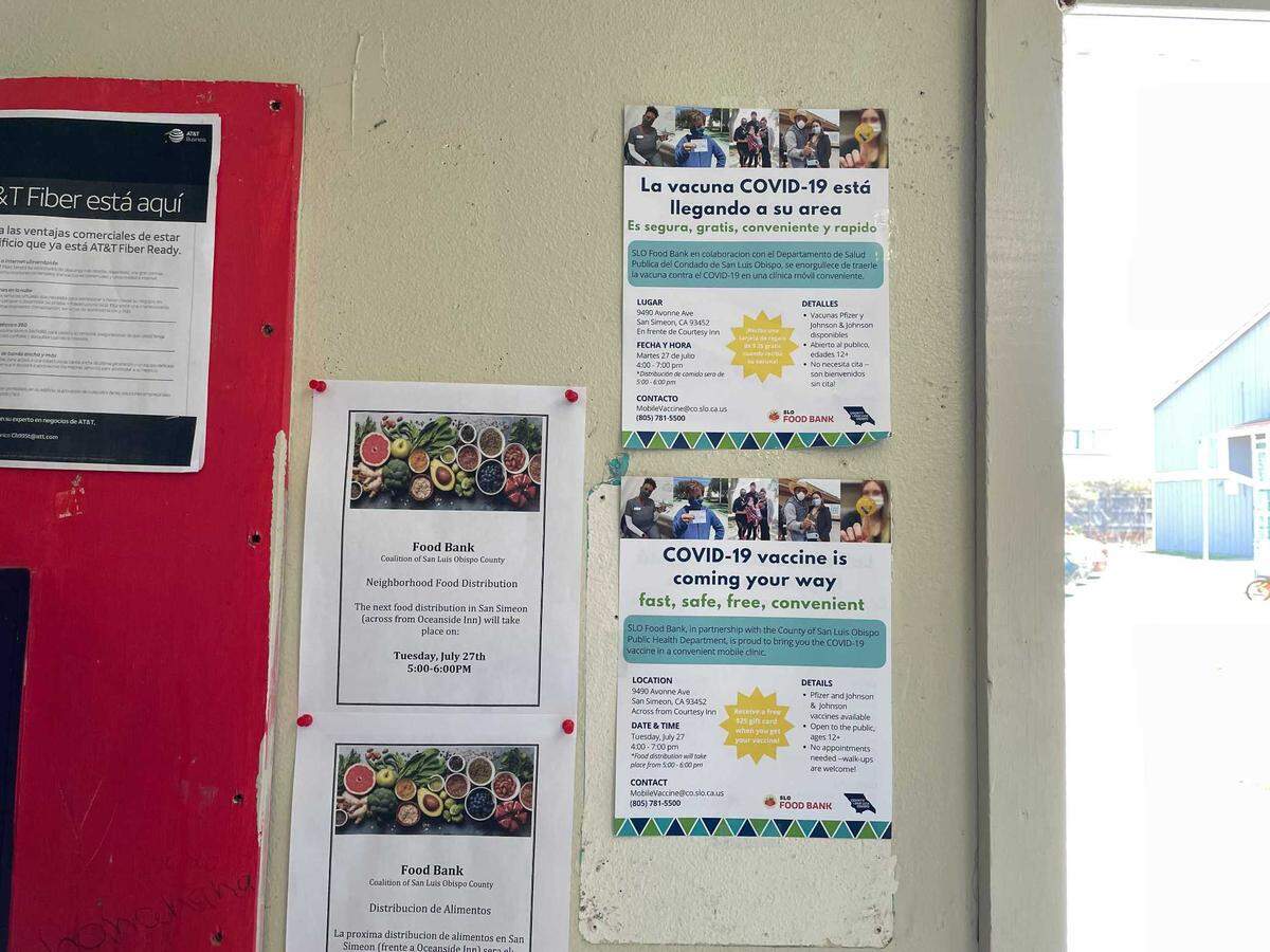 English- and Spanish-language flyers advertising a San Luis Obispo County Public Health Department COVID-19 vaccine clinic hang in a laundry room at a San Simeon apartment complex. The agency is conducting increasing amounts of outreach in areas of the county where vaccination rates are lower.
