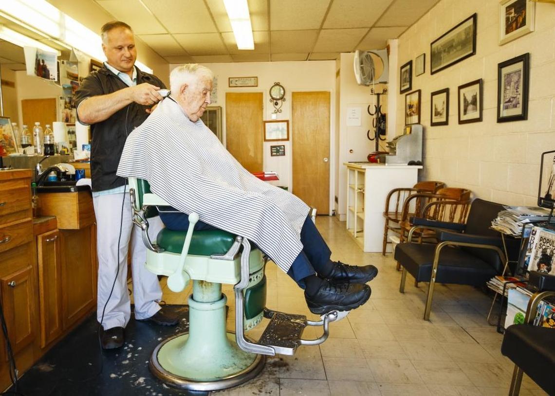 Mark Roetker gives Clancy Reno a haircut at the SLO Town Barber Shop in the Laurel Lane shopping center on April 20, 2016. Roetker's shop is one of the businesses affected by the ongoing construction at the shopping center.