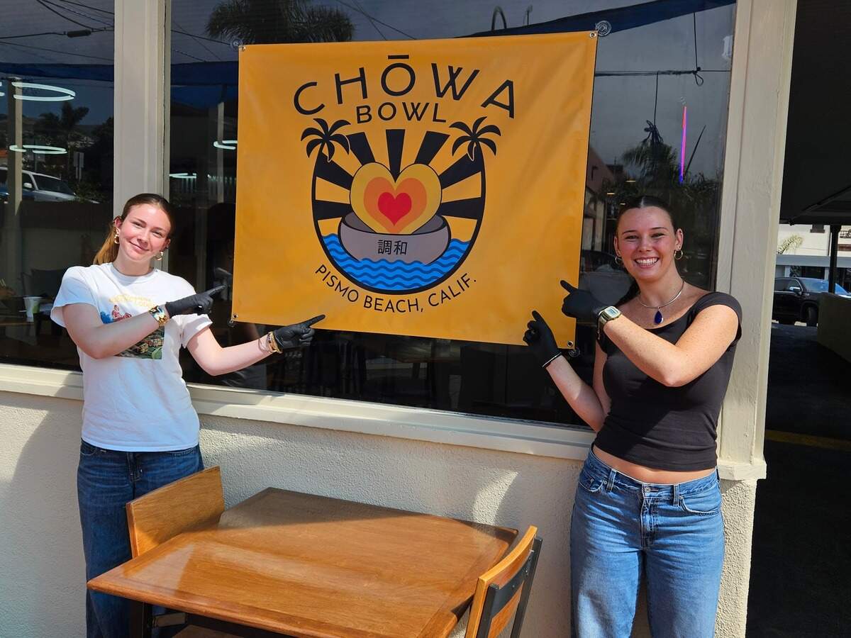 Chowa Bowl has opened a new location in Pismo Beach, serving poke bowls and ramen to visitors. Cashiers Reagan Shattuck, left, and Fiona Durham pose with a sign for the new restaurant. 