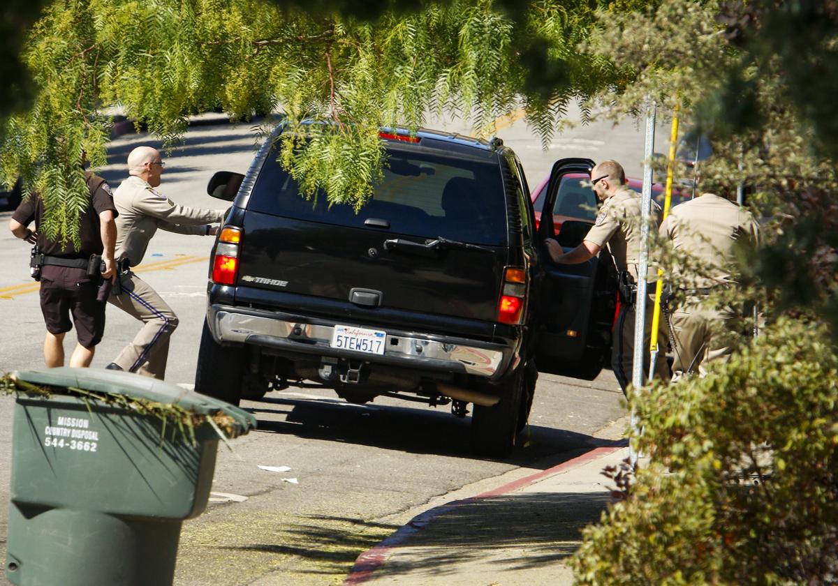 The driver of a dark colored Chevy Tahoe, which took authorities on a slow speed chase around San Luis Obispo, is pulled from his vehicle by CHP officers near Cal Poly Thursday morning.