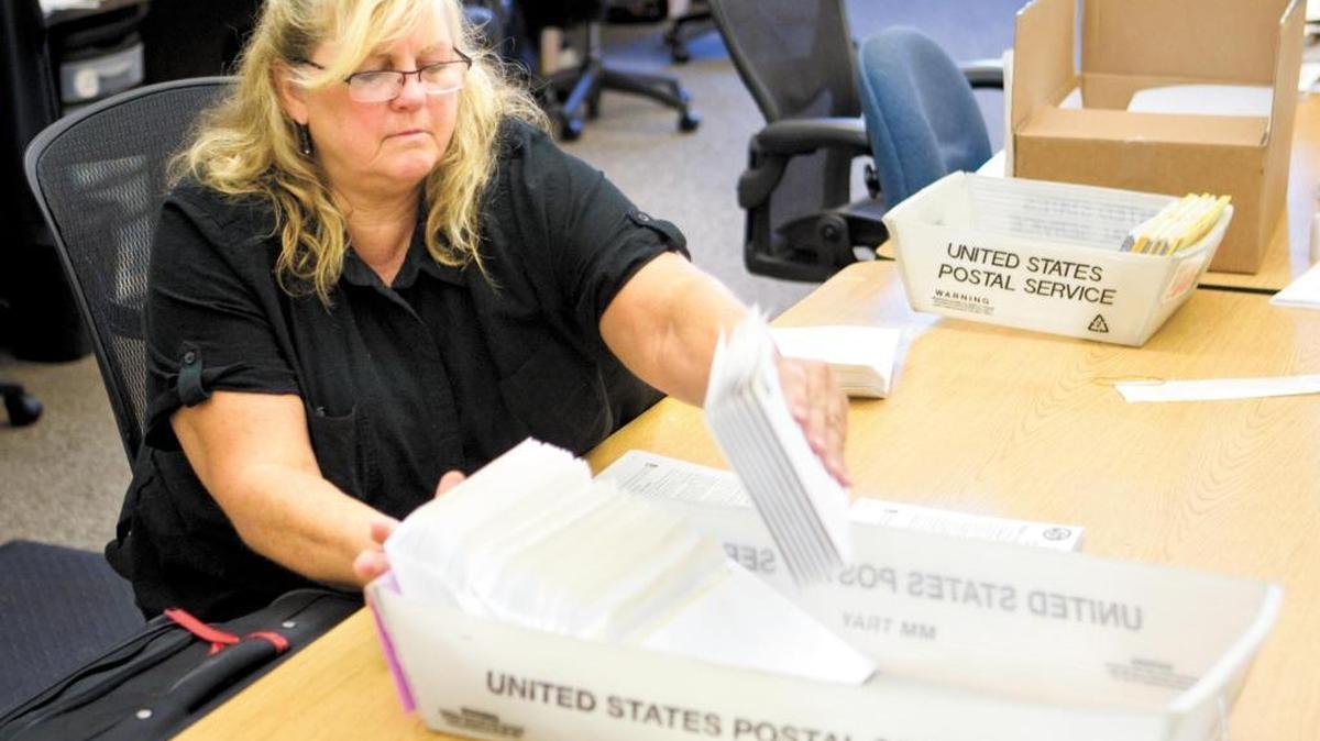 Cindy Osgood, temporary election worker with the San Luis Obispo County Clerk’s Office prepares mail-in ballots to be sent out to voters in 2014.