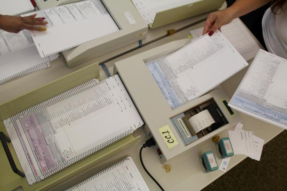 SLO County election workers send mailed-in ballots through counting machines.