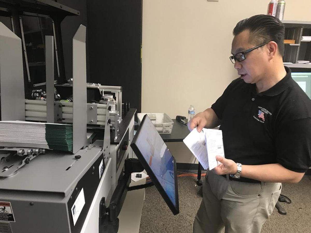 San Luis Obispo County Clerk-Recorder Tommy Gong processes vote-by-mail envelopes through a machine that photographs the signature in 2018. Gong is preparing for the November 2020 election, which will rely heavily on mail-in voting.