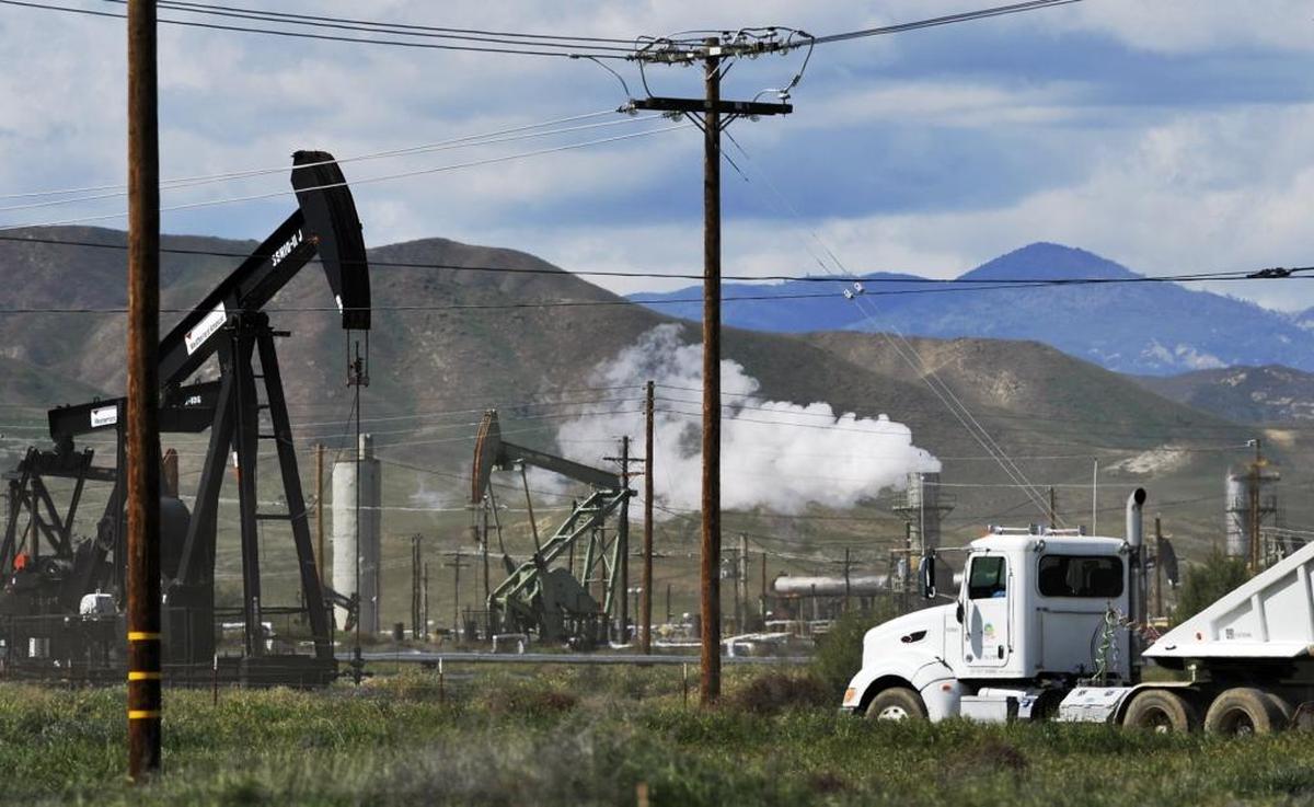 The land west of Coalinga features active oil pumps and trucking activity.