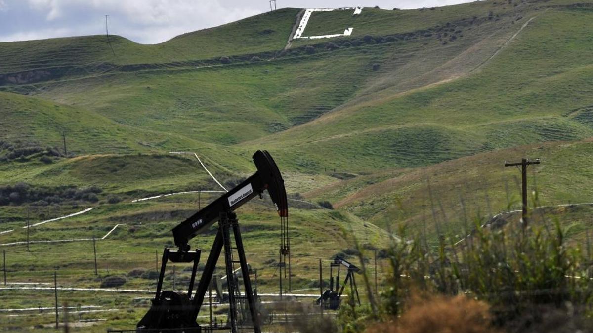 A large letter on a hillside designates the city of Coalinga as oil pumps continue working.