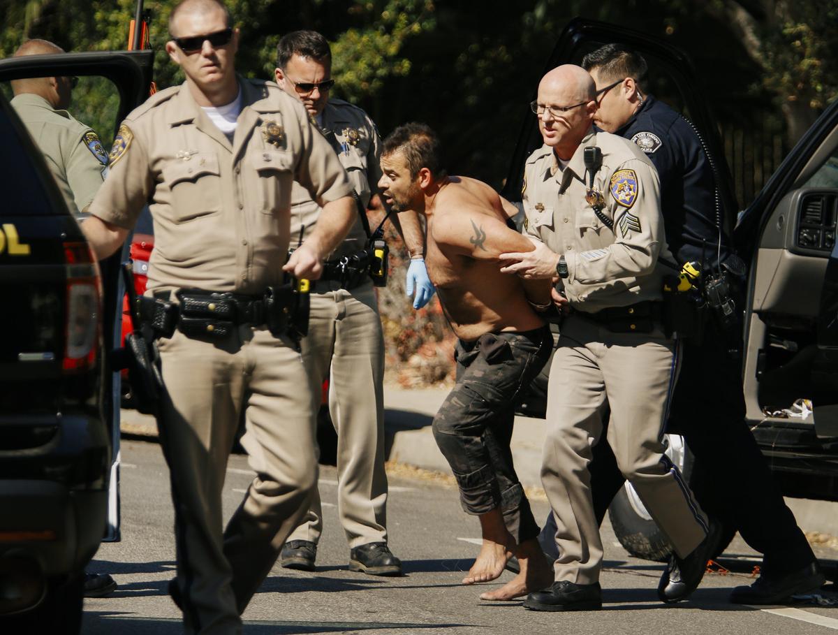 The driver of a dark colored Chevy Tahoe, which took authorities on a slow speed chase around San Luis Obispo, is taken into custody by CHP officers near Cal Poly Thursday morning.