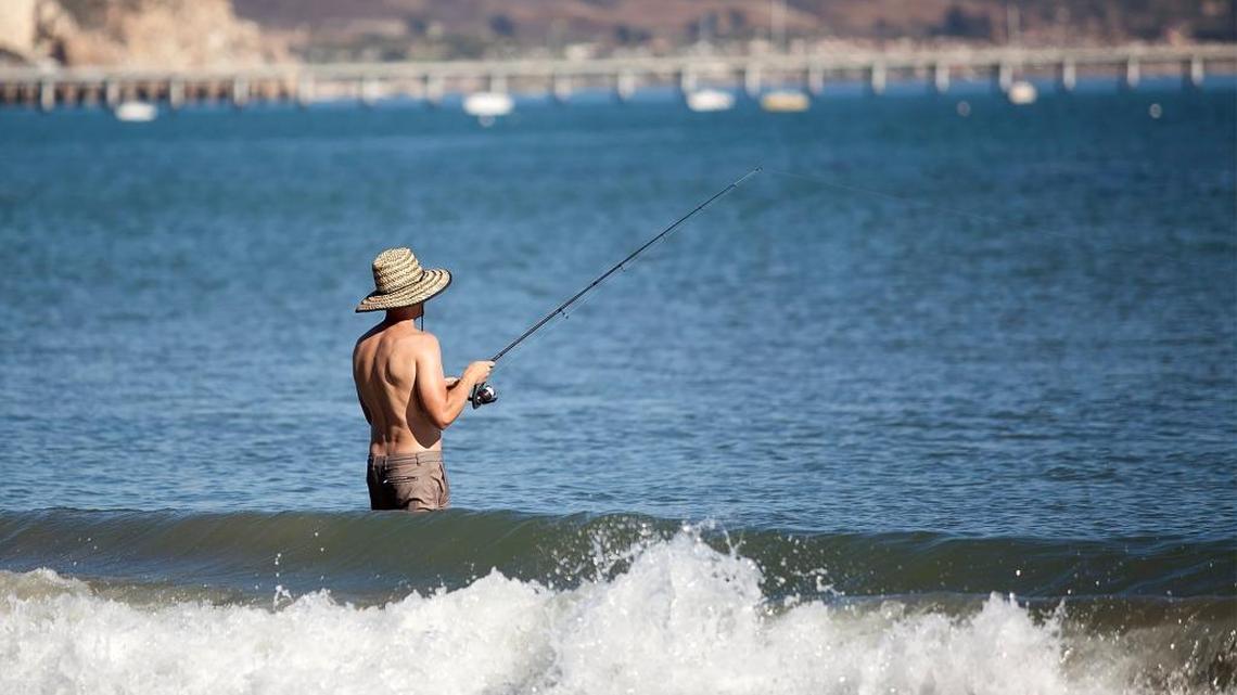 Aaron Powell of Bakersfield fishes for perch in the cool waves during a hot and sunny Sunday at Olde Port Beach. He did catch a few keepers.