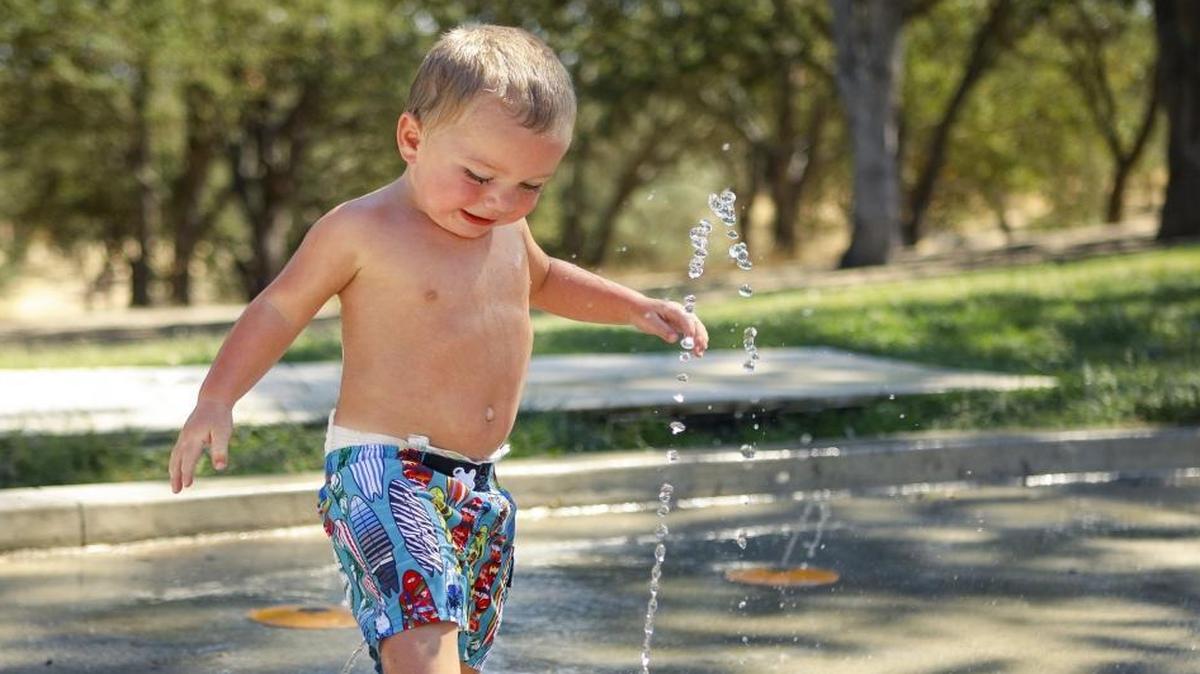 Axel Paquette, 1, from Carrizo Plain, plays in the water splash area at Heilmann Park on Tuesday in Atascadero, where high temperatures reached the triple digits.
