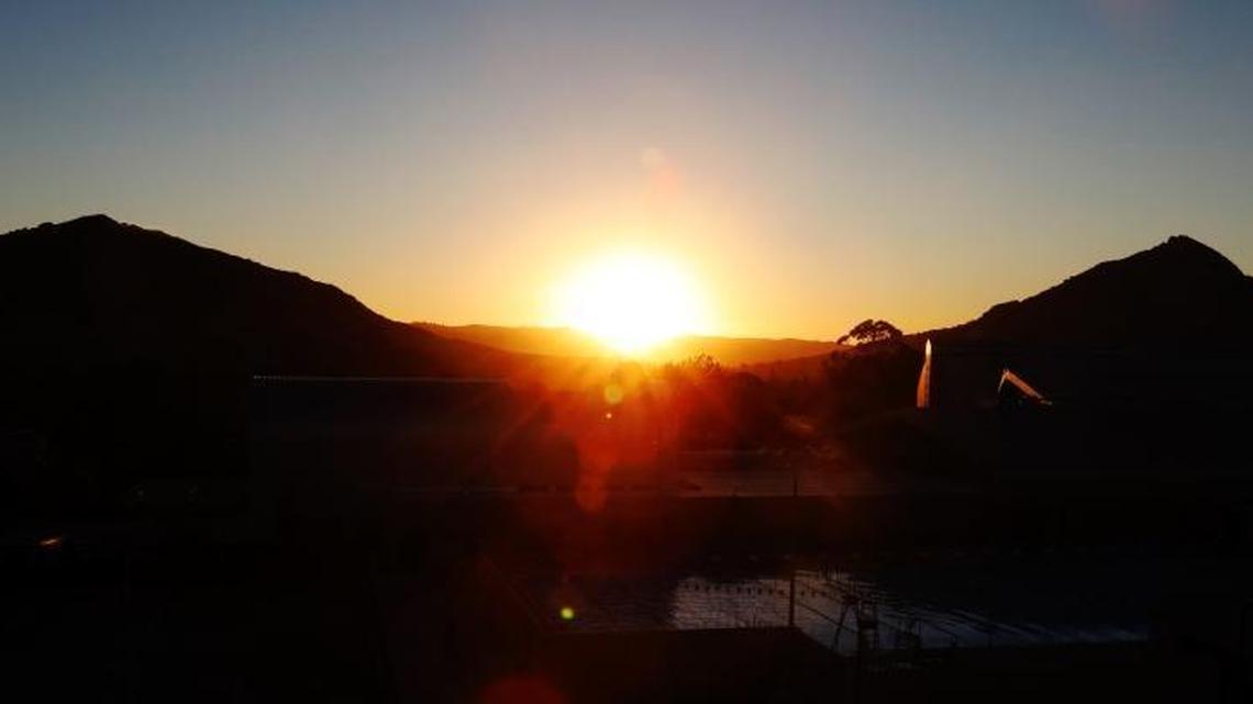 The sun sets on Tuesday, October 24, 2017, between Cerro San Luis at left and Bishop Peak right. The view is from Cal Poly.