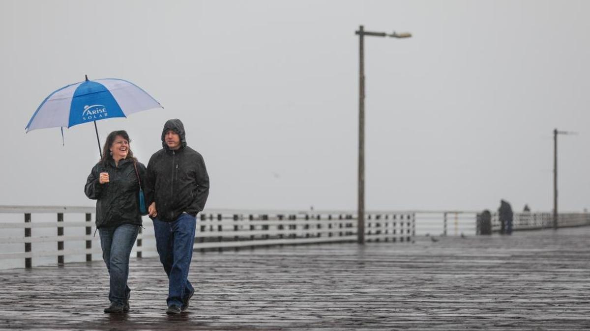 Rebecca and Brian Wiebe of Fresno walk along the Pismo Beach Pier during a storm in December.