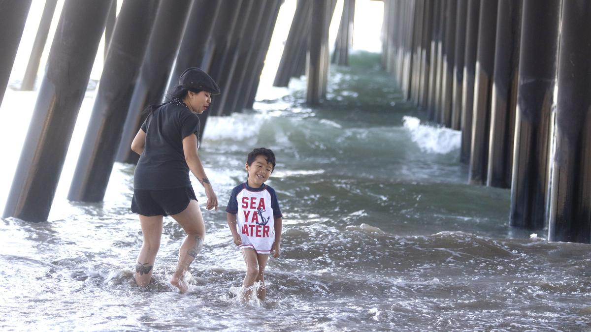 Viane Raiden and son Macias, 4, play under the Pismo Beach Pier on a warm July day. Crowds flocked to the coast as hot weather swept the region.