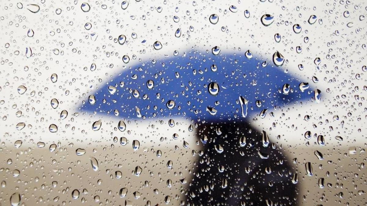 A man walks past Mission San Luis Obispo de Tolosa under the protection of his umbrella. The Central Coast was hit with a mighty storm over the weekend.