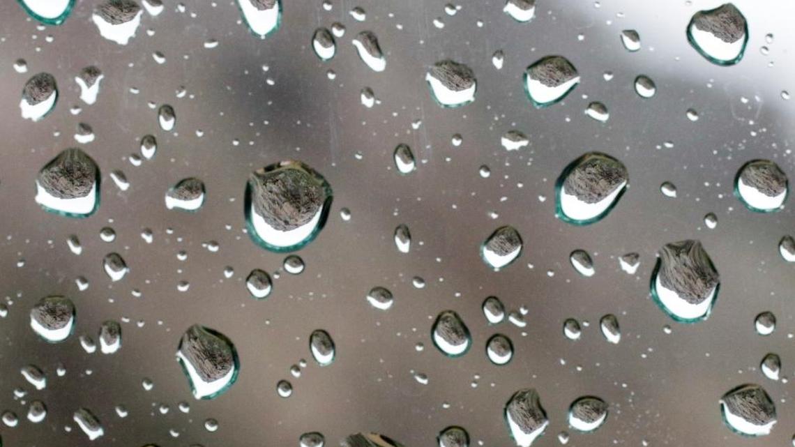 Morro Rock is inverted in the raindrops on this car window.